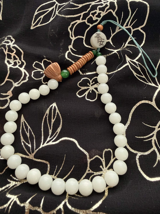 Handheld Lotus Pod & 'Ping An' Peace Worry Beads – Serene White & Jade Green Holding Bracelet